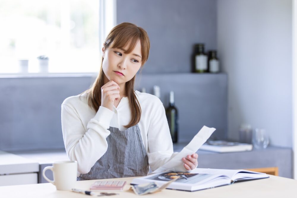 レシピを見ながら首をかしげる女性