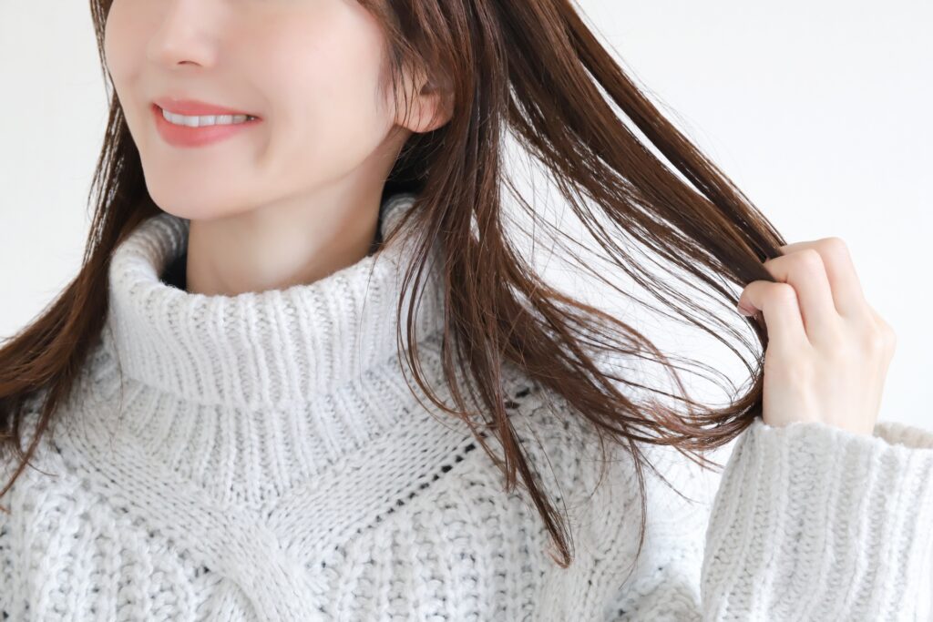 髪の毛をなでている女性