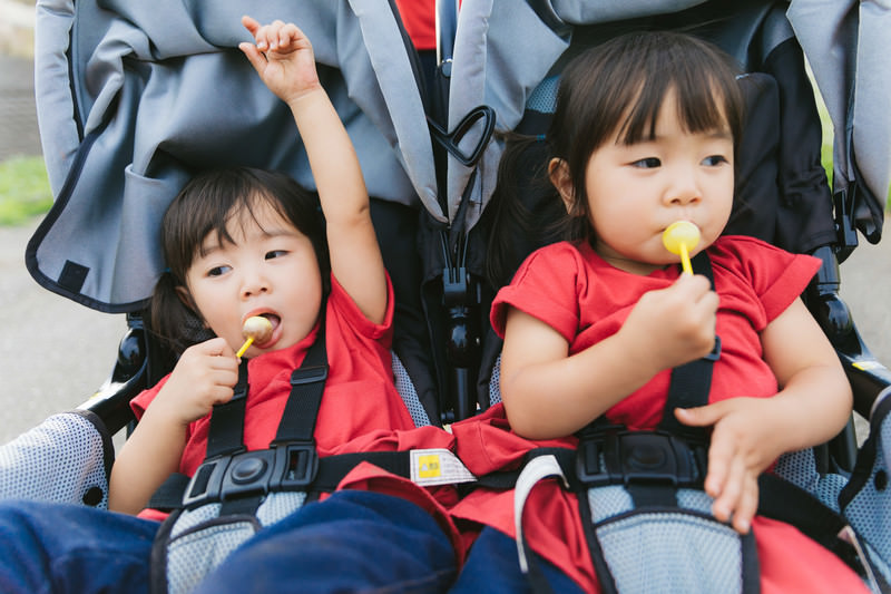 ベビーカーに乗っている3~5歳の女の子の写真