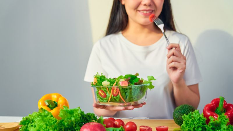 野菜サラダを食べている人の写真